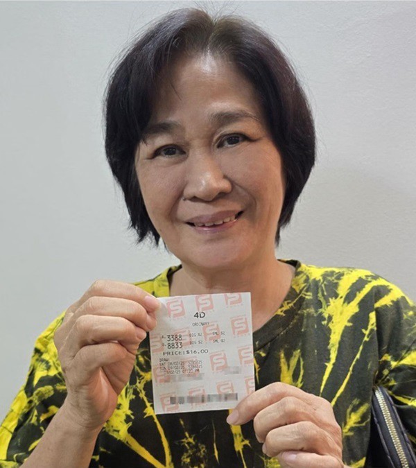 Bà Minh cầm tờ vé số độc đắc. Ảnh: zaobao